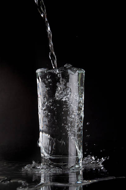 istock Pouring soda water into glass on a black background 2210584451
