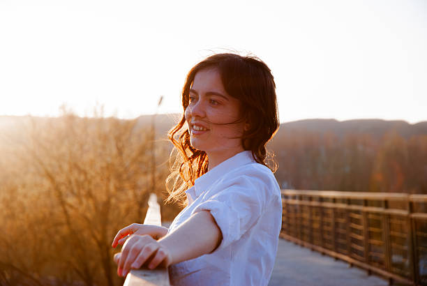 istock Woman enjoying sunset on bridge in nature setting 2210585901
