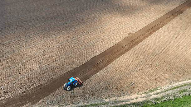 istock High angle view of a blue tractor plowing an uncultivated field creating a perfect diagonal starting the work in the field in Spain 2210586269