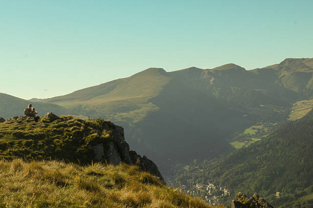 istock Hikers on a mountain summit overlooking a sunlit valley, Auvergne 2210587864