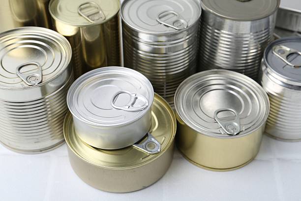 istock Many closed tin cans on white tiled table, closeup 2210588437