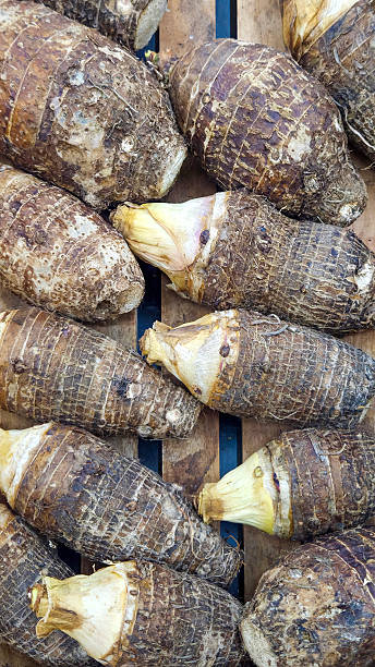 istock Fresh taro roots stacked on wooden crate 2210588614