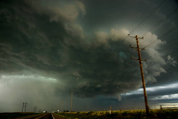 Here comes the rain! Driving down a west Texas highway under dramatic billowing storm clouds on a summer evening.