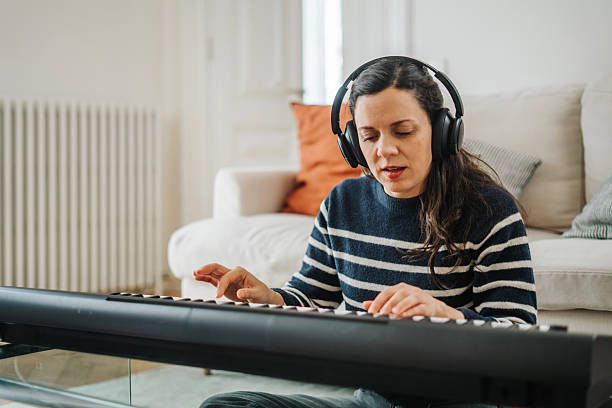 istock Woman playing synthesizer at home 2210598482