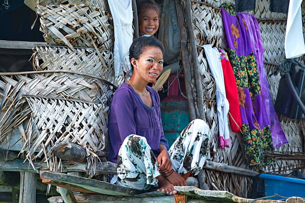 Semporna, Malaysia. November 30, 2018. Portrait of a young gypsy woman on the threshold of her own hut in the village of sea gypsies, located in the reef shallow waters of the Pacific Ocean.