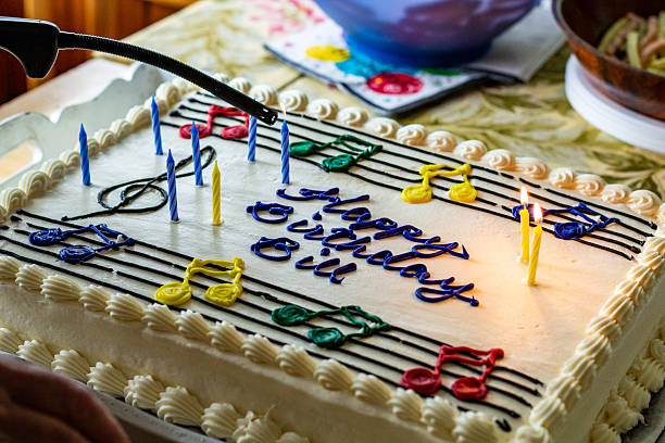 istock Musical-Themed Birthday Cake with Lit Candles on a Celebration Table 2210600393