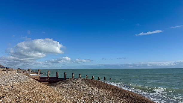istock Serene coastal view with gentle waves and a clear blue sky over smooth pebbles at a tranquil beach setting 2210604352