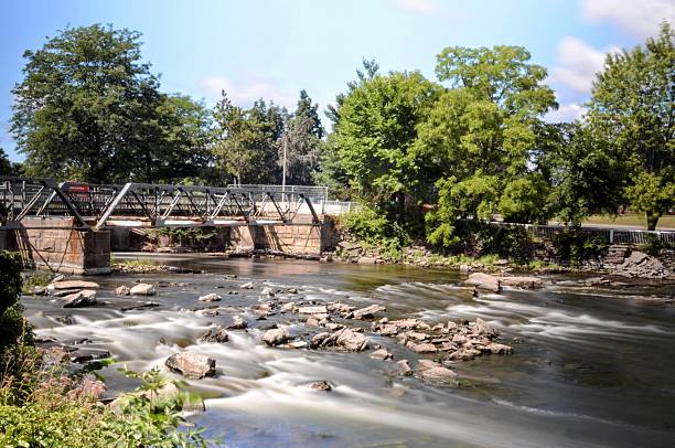 istock Pedestrian Bridge Over Gentle Rapids in Ontario Park Setting 2210604942