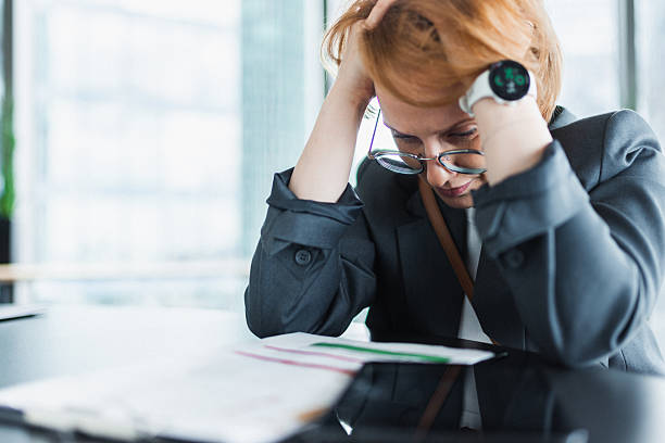 istock Frustrated businesswoman overwhelmed with paperwork in a modern office setting 2210605979