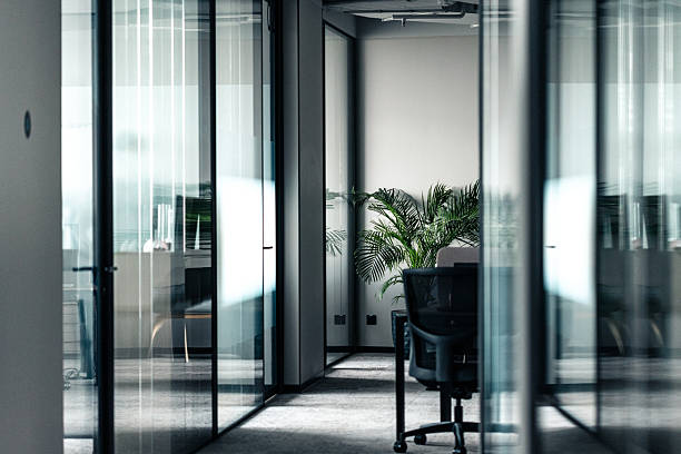 istock Modern office space with glass partitions and a green potted plant 2210606865