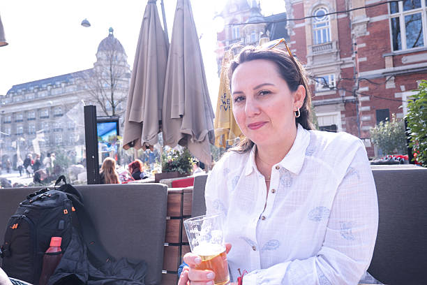 A solo traveler woman explores Amsterdam in springtime, enjoying local food and drinks, capturing memories with selfies, and embracing the joy of discovering a new city.