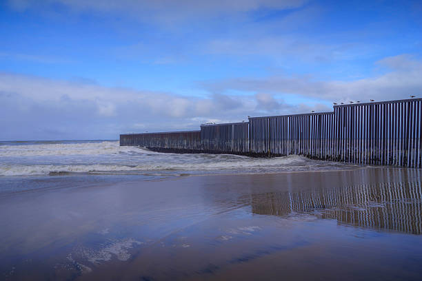 istock Border wall slices through Tijuana beach into the Pacific, in Mexico 2210607605