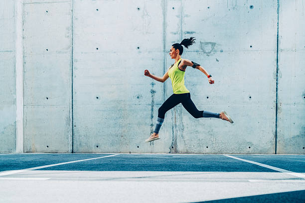 istock Woman sprinting against concrete backdrop 2210614636