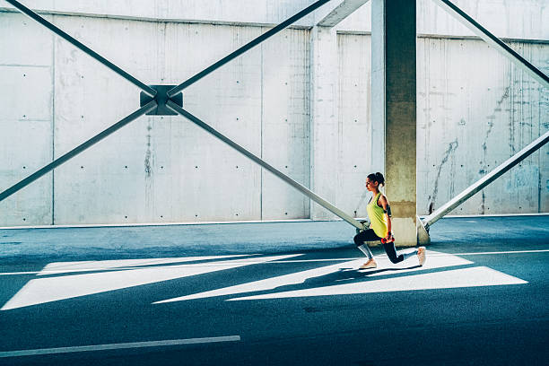 istock Woman performing lunges in modern concrete architecture 2210614800