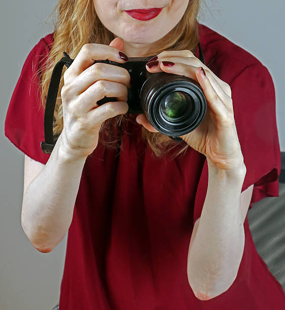 Digital photo camera held by female photographer taking pictures