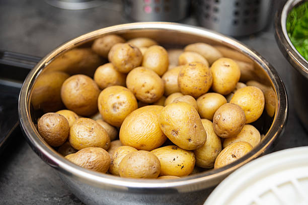 istock Fresh baby potatoes in metal bowl. 2210615976