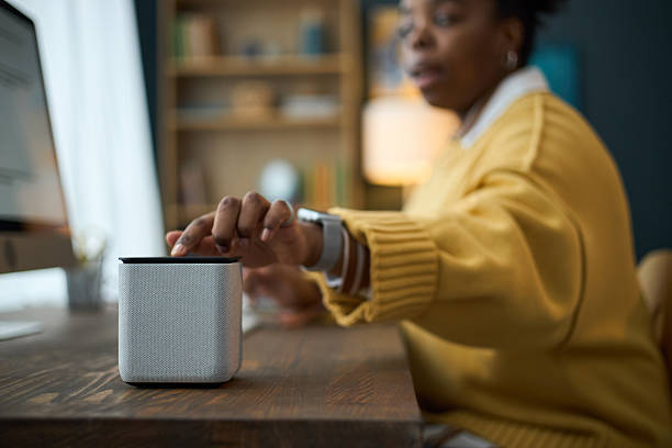 istock Woman Adjusting Smart Speaker in Modern Home Office 2210616809