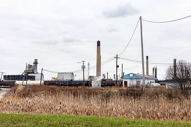 istock Industrial Facility with Chimneys and Shipping Containers on a Cloudy Day 2210619401
