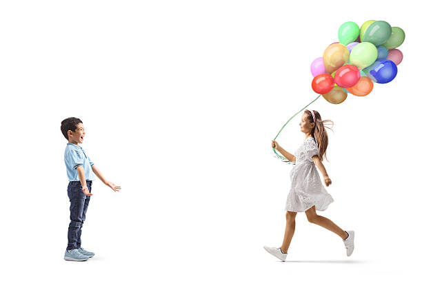 istock Girl with balloons running towards a boy 2210620907