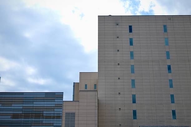 A modern beige building with minimal windows rises starkly against the cloudy Philadelphia sky.