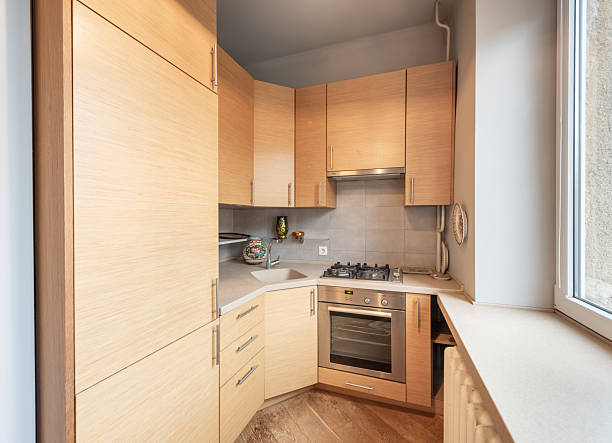 istock Modern Home Compact Kitchen Interior with Light Wooden Cabinets and Gas Stove 2210621870
