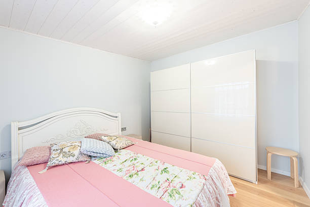 istock Bright Bedroom with Pastel Bedspread and Modern Minimalist Wardrobe 2210622071