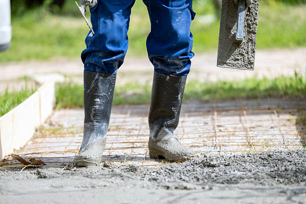 Outdoor shot of a construction worker finishing concrete with trowel and plasterer