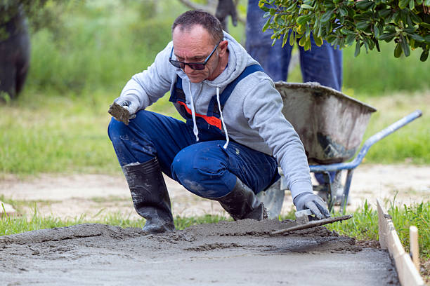 Outdoor shot of a construction worker finishing concrete with trowel and plasterer