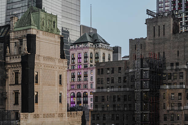 A close-up view of a modern skyscraper’s facade, showcasing its sleek, repetitive window patterns bathed in soft, natural light. The minimalist design and clean lines emphasize contemporary architectural trends, making this image a great fit for themes of modern urban living, corporate environments, or architectural design studies. The subtle lighting adds a serene mood to the urban setting.