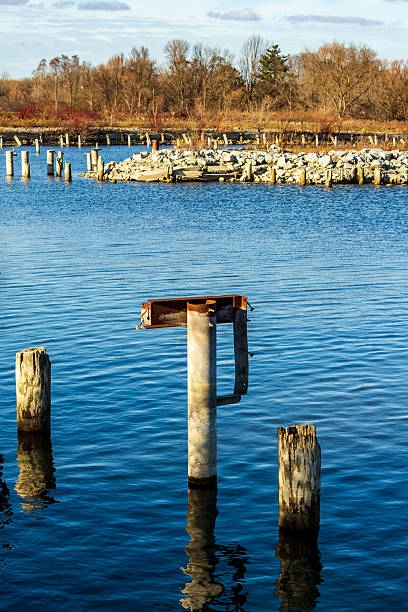istock Rustic Pier Remains Over Calm Waters Surrounded by Natural Landscape 2210626357