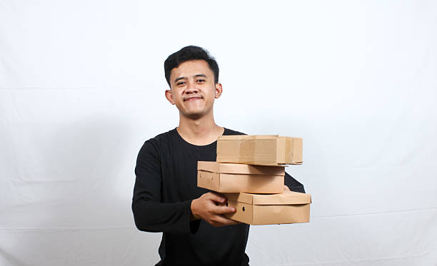 istock Asian man giving package to customer isolated on white background 2210627947