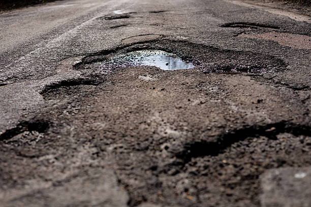 istock Dangerous potholes and cracks are visible on the highway surface, indicating significant road damage that requires immediate repair efforts 2210628314