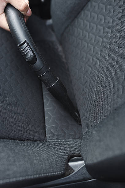 istock Person Using Vacuum Cleaner to Clean Car Seat Upholstery 2210628733