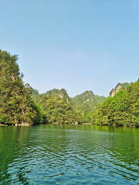 istock Calm lake surrounded by lush, green hills or mountains 2210634490