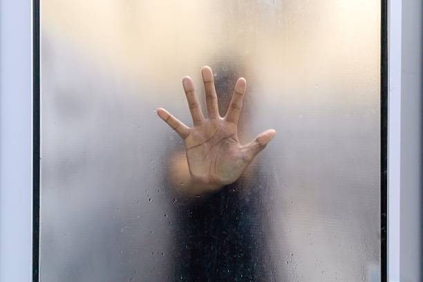 istock Hand behind frosted glass door. 2210638127