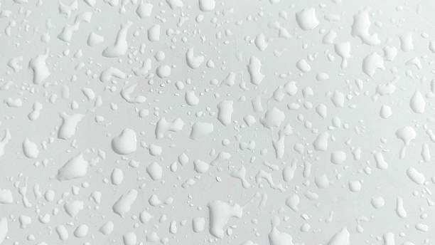 istock Glistening Water Droplets on a Smooth White car surface 2210639454