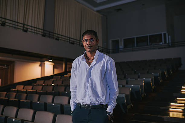 istock Confident Young indian Man Standing in Empty Auditorium 2210646514