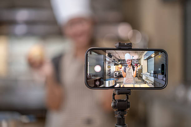 istock Smartphone Capturing Chef Filming Cooking Video in Kitchen 2210647283