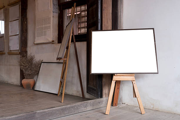 istock Easel with vertical canvas. Blank menu frame mock-up stands on wooden table in bar restaurant 2210647379