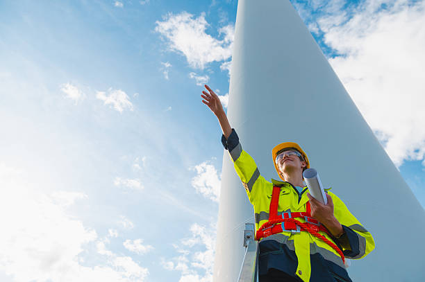 istock man in a yellow vest is pointing at a large structure 2210647577
