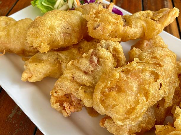 istock Close-up, Fried squid served on a white plate on a wooden table. 2210650617