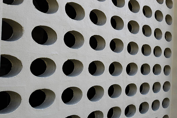 a concrete wall with numerous holes in roles and columns. creative a peek-a-boo or hive visual effect. texture pattern abstract background