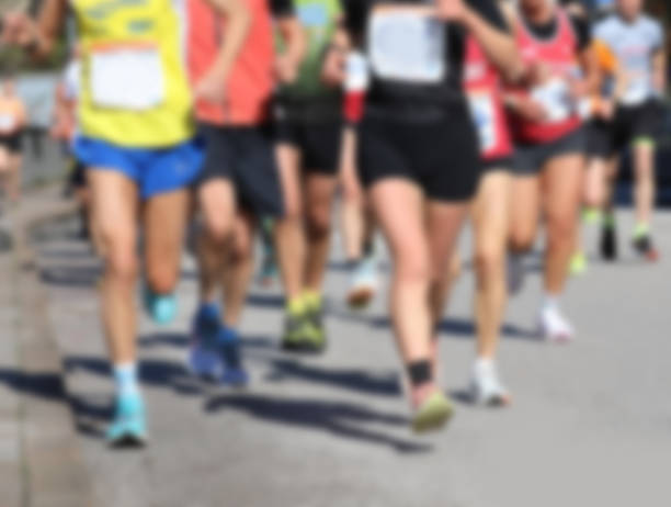istock Intentionally blurred background of many runners legs is ideal as a backdrop for the concept of sport 2210655157