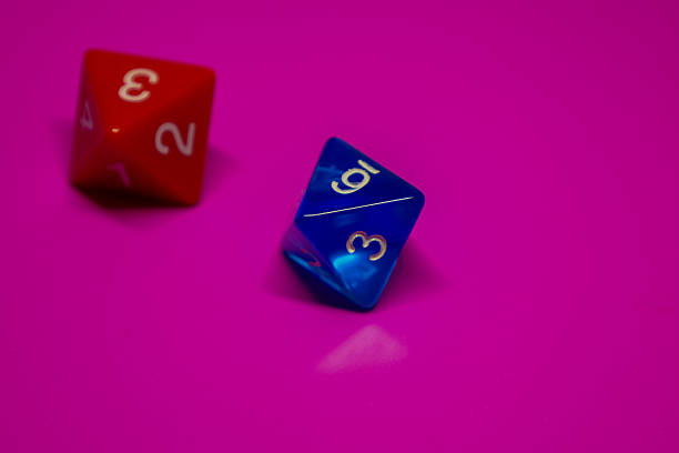 istock Two multi-sided dice for tabletop games on a vibrant pink background. The red die shows the values 2 and 3. The blue die shows the values 3 and 9 (or 6). 2210657482