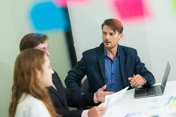 istock Professionals engaged in a collaborative meeting discussing project plans in a modern office environment 2210659216