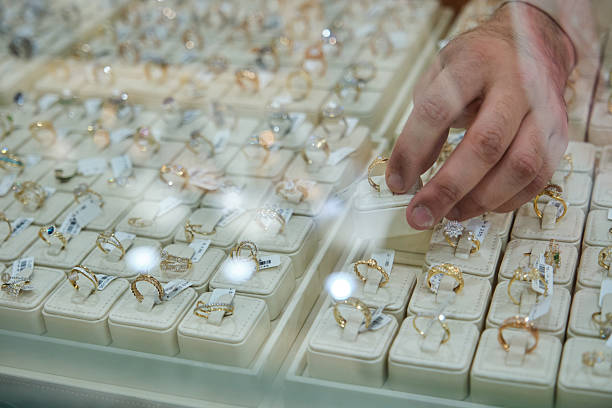 istock Male owner picking up gold rings from display 2210661078