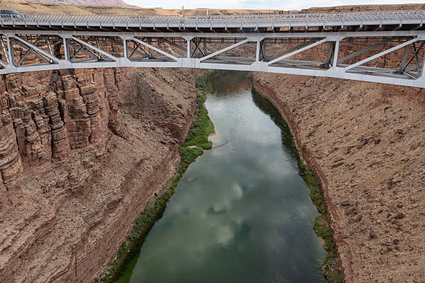 istock Stunning view of a river flowing under a bridge in a canyon during a cloudy day 2210661723