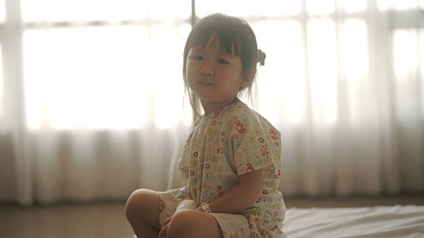 Young Asian girl is sick in bed at the hospital.