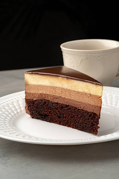istock Sliced chocolate mousse cake displayed on a decorative plate beside a cup of coffee at a cozy cafe 2210663816