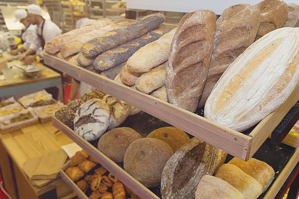 Freshly baked bread assortment displayed on wooden shelves in a cozy bakery